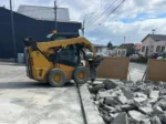 Arriendo de minicargador New Holland con martillo hidráulico, aguilón y horquillas. Ideal para trabajos en espacios reducidos. Cotice con Servisan.